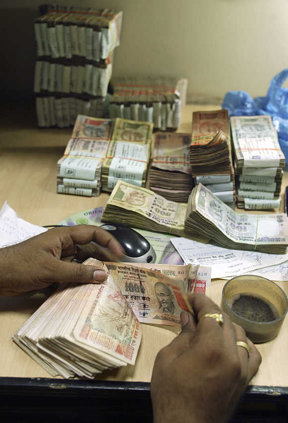 A cashier counts rupee notes inside a bank in Amritsar.