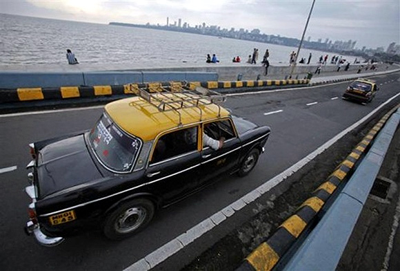 A Premier Padmini taxi travels along Marine Drive in Mumbai.