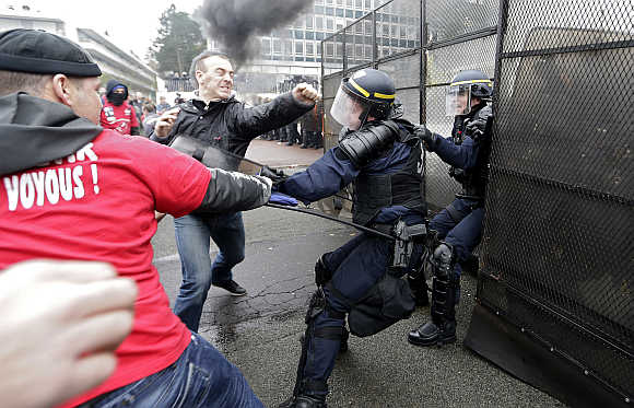 Protestors scuffle with French CRS riot police in front of tyre maker Goodyear Dunlop France headquarters during a demonstration against job cuts in Rueil Malmaison, near Paris.