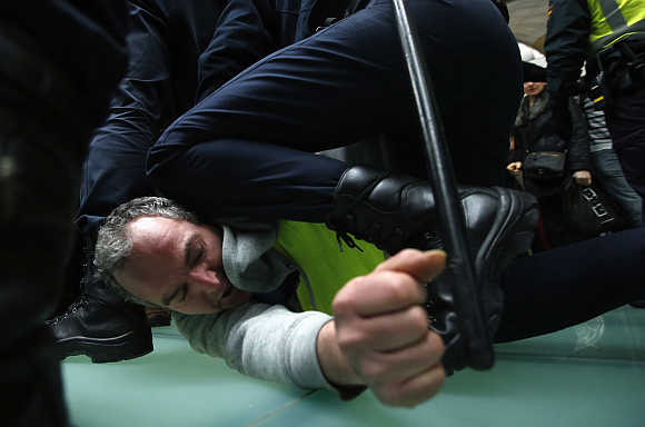 An Iberia worker is arrested by Spanish riot police officer during clashes at Madrid's Barajas airport.