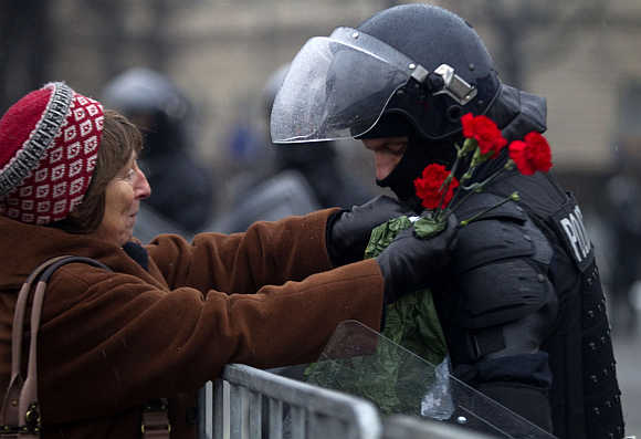A woman gives carnation to a riot police during a protest against government austerity policies and budget cuts in Ljubljana, Slovenia.