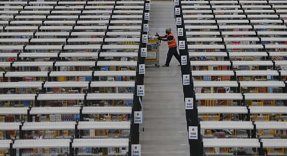 A worker collects orders at Amazon's fulfilment centre in Rugeley, central England.