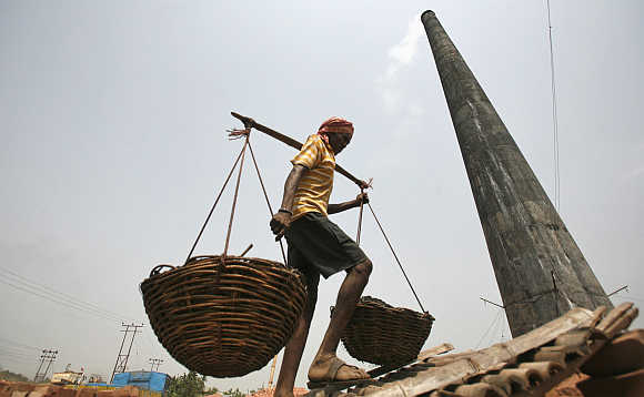 A worker carries coal in baskets at a wholesale coal shop on the outskirts of Agartala, capital of Tripura.
