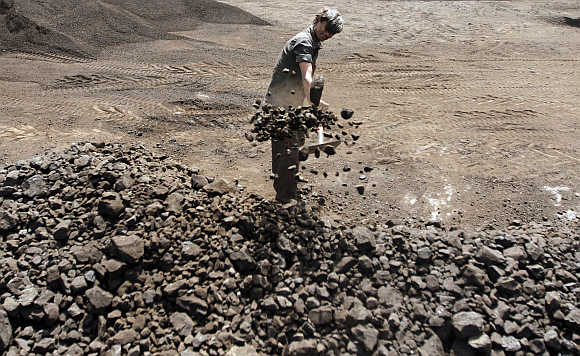 A worker shovels coal at a yard in Ahmedabad.