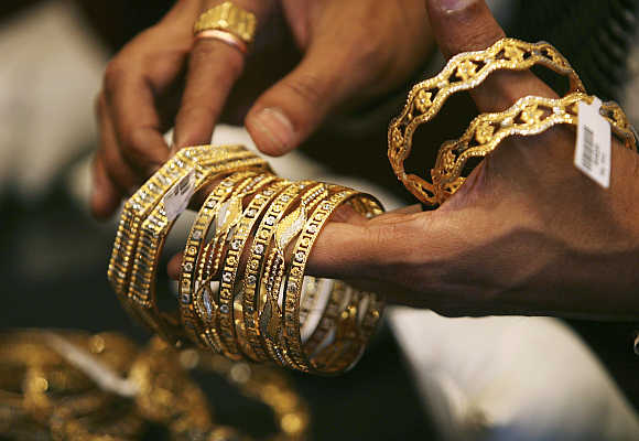 A shopkeeper shows gold bangles to a customer at a jewellery shop in Mumbai.