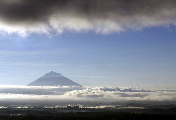 Peak of Gunung Agung rises above the clouds in eastern Bali.