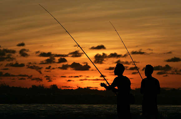 Anglers fish at sunset off Legian beach on the Indonesian resort island of Bali.