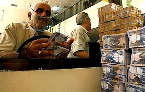 A client counts his money near a bank's teller. Photograph: Bassim Shati/reuters