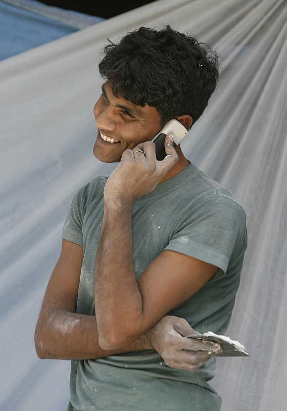 A labourer talks on his mobile phone at a construction site in New Delhi.