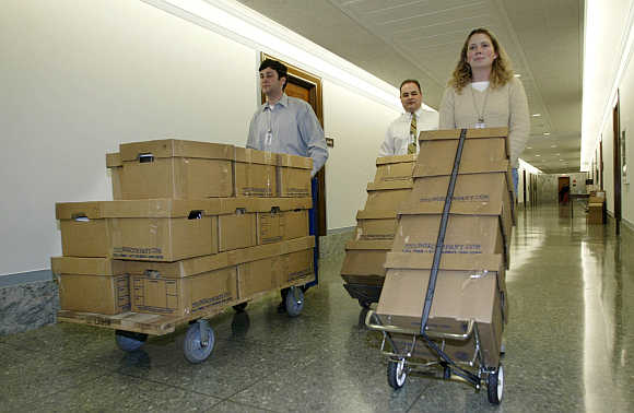 US Senate Finance Committee workers push boxes containing Enron tax records after they were delivered to the committee office at the Senate Dirksen building on April 5, 2002.