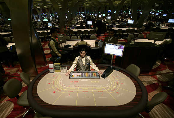 A croupier waits for gamblers at a table inside the Marina Bay Sands casino in Singapore.