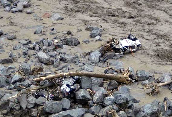 Vehicles are pictured in the flooded waters of a stream after heavy rains in Uttarakhand.