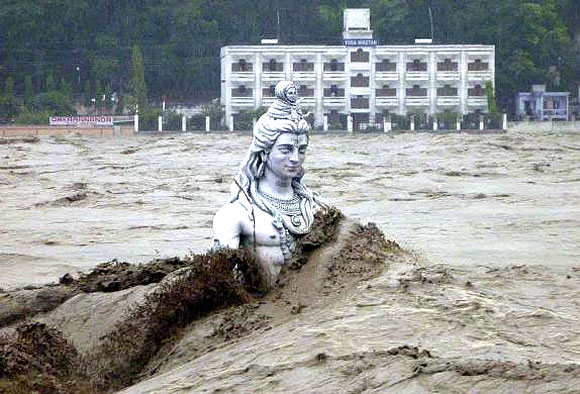 A submerged statue of Lord Shiva stands amid the flooded waters of river Ganges at Rishikesh.