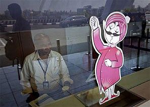 An Air India ticketing staff member sits at a closed counter in front of the Air India mascot. Photograph: Vivek Prakash/Reuters