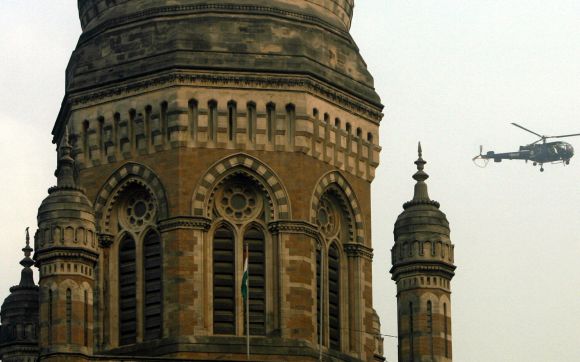 A helicopter flies past the dome of Mumbai Municipal Corporation's building.