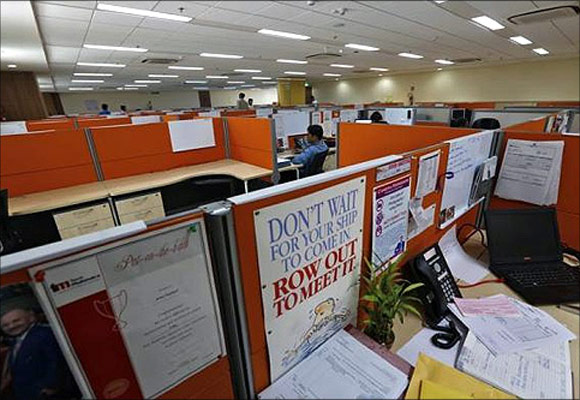 Employees work at their desks inside Tech Mahindra office building in Noida on the outskirts of New Delhi. 