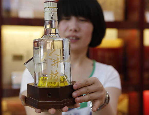 A clerk shows Swellfun baijiu at a liquor shop in Beijing.
