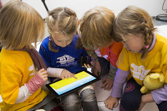 Children play with Microsoft's 'Schlaumaeuse' education software that runs on a Windows 8 operated tablet computer during the program's presentation in Berlin, Germany.