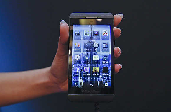 A salesperson displays a BlackBerry Z10 during the launch of the smartphone in Mumbai.
