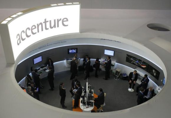 Visitors look at devices at Accenture stand at the Mobile World Congress.