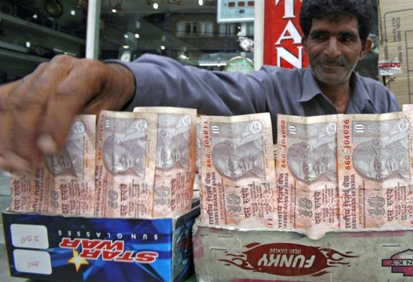 A Kashmiri money changer Nissar Ahmad displays newer Indian rupee notes in Srinagar.