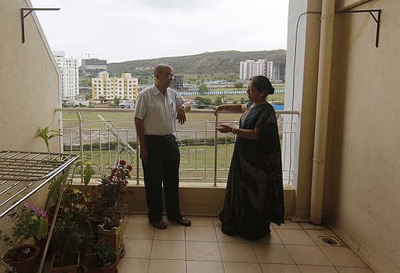 Suresh Chitre, 67, and his wife Rekha Chitre, 63, stand on the balcony of their flat at the Athashri retirement village in Baner, on the outskirts of Pune.