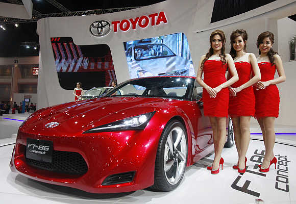Models stand beside a Toyota FT-86 in Bangkok, Thailand.