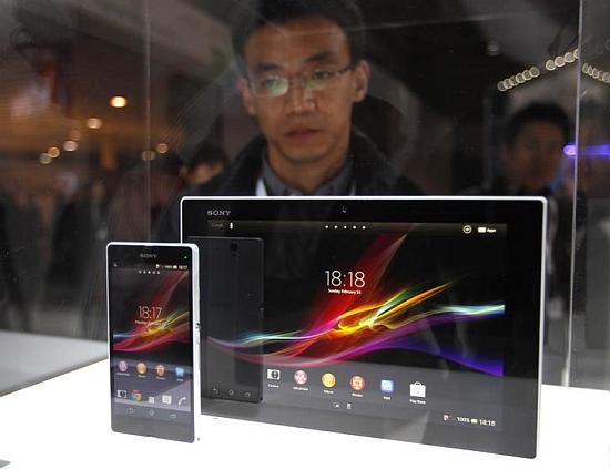 A visitor looks at the new Sony Xperia Z phone and tablet through a glass window during the Mobile World Congress in Barcelona.