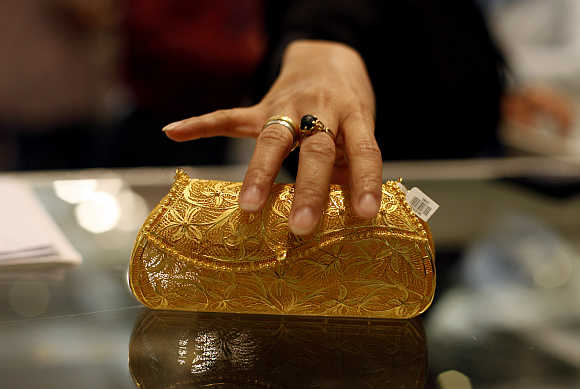 A visitor touches a mobile phone purse made of gold at the Jakarta International Jewellery Fair.
