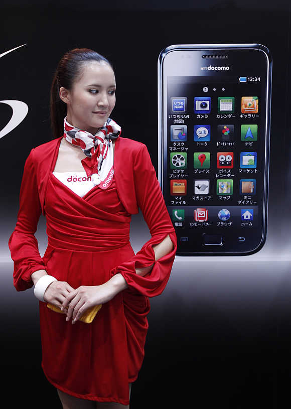 A campaign girl stands next to a billboard of Samsung Electronics' Galaxy S smartphone in Chiba, east of Tokyo.