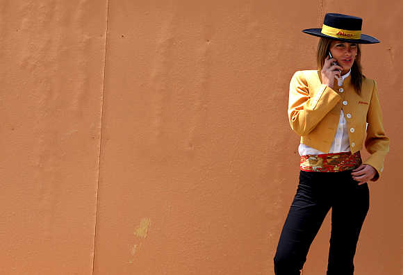 A woman wearing a traditional flamenco costume talks on her mobile phone in Seville, southern Spain.