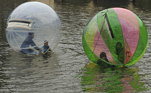 People float in balloons on a lake in Hanoi, Vietnam.