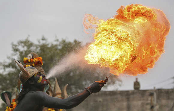 A man dressed as a demon performs with fire during a procession ahead of the Mahashivratri festival in Jammu.