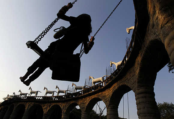 A women swings on rock arches at Nek Chand's Rock Garden in Chandigarh.