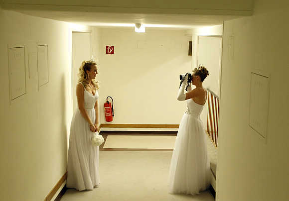 Dancers from the Young Ladies' Committee take photographs as they get ready prior to the opening ceremony at the traditional Opera Ball in Vienna.