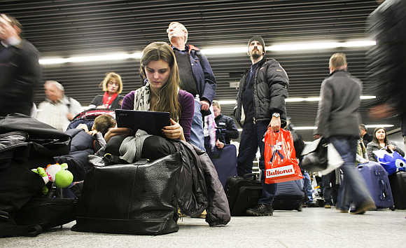 A woman watches a film as she waits at Frankfurt's airport.