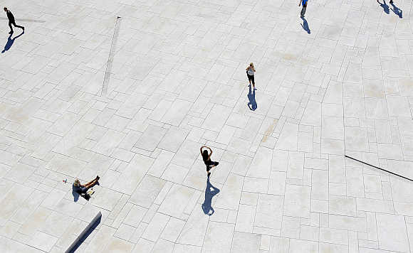 A woman poses for a picture in front of the Oslo Opera House.