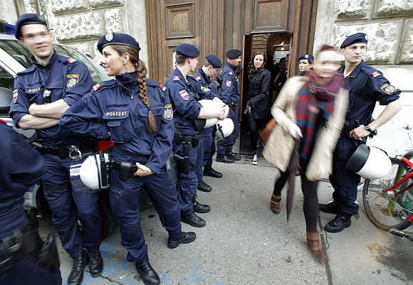 Police are seen as students leave Vienna University through a side entrance in Vienna, Austria.