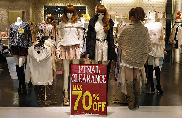 A woman works next to a sale sign at a shopping district in Tokyo, Japan.