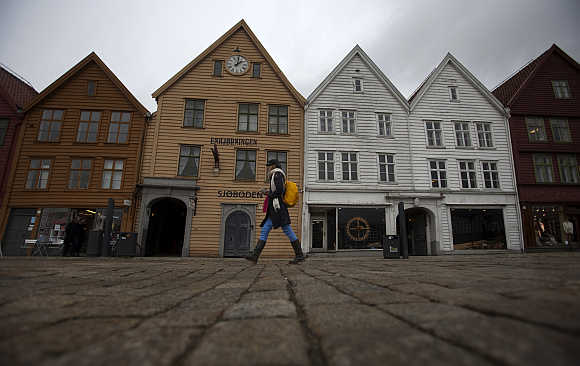 A woman walks near Bryggen (the Wharf) near the marina in downtown Bergen, Norway.