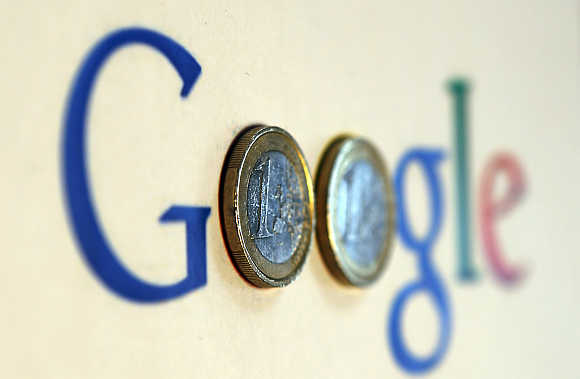 An illustration picture shows a Google logo with two one Euro coins, taken in Munich, Germany.