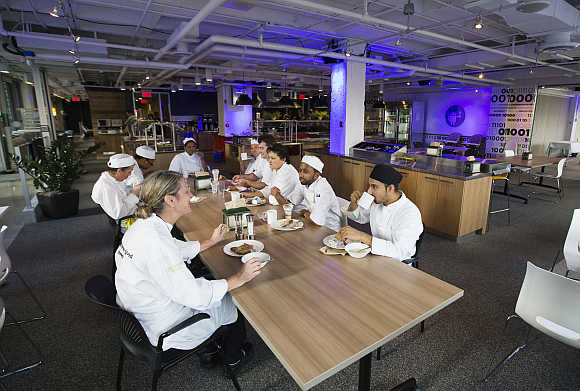 Food preparation team sit down to eat at the Google office in Toronto.