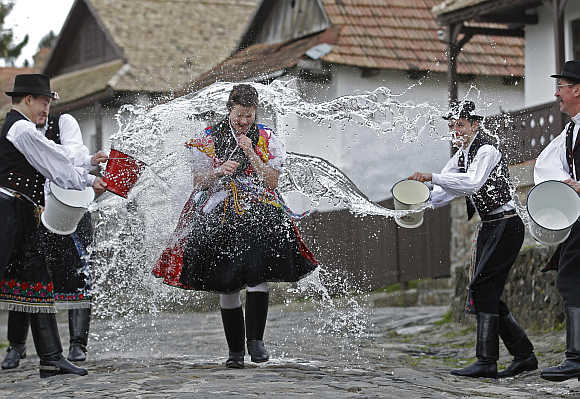 A woman runs as men throw water at her as part of traditional Easter celebrations near Budapest.