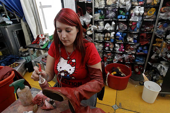 A woman mends shoes backstage before Cirque du Soleil's show in Lima.