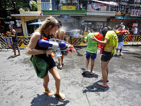 Tourists use toy guns as they participate in a water fight during the Songkran Festival celebration at Khaosan road in Bangkok.