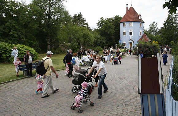 Visitors walk down the main street at Moomin World theme park in Naatali, Finland.