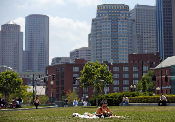 A woman reads a book on the Rose Kennedy Greenway in Boston, Massachusetts, United States.
