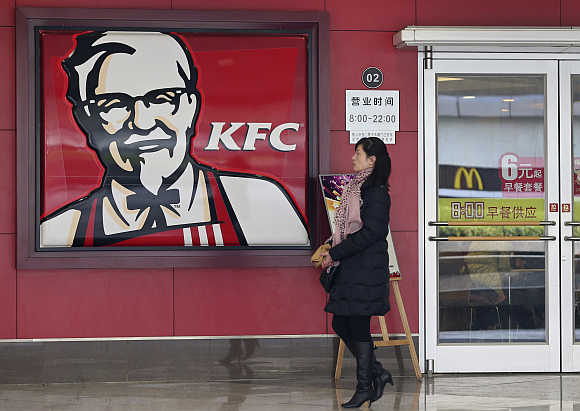 A woman walks past a KFC restaurant in Wuhan, Hubei province, China.