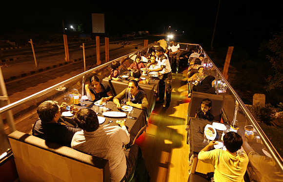 People dine on a double-decker bus converted into a mobile restaurant in Ahmedabad.