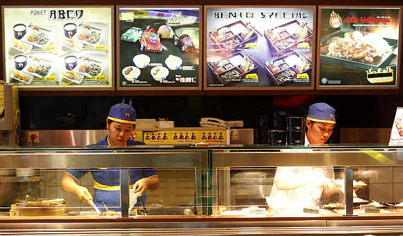 Workers prepare food at a fast food outlet in Jakarta, Indonesia.
